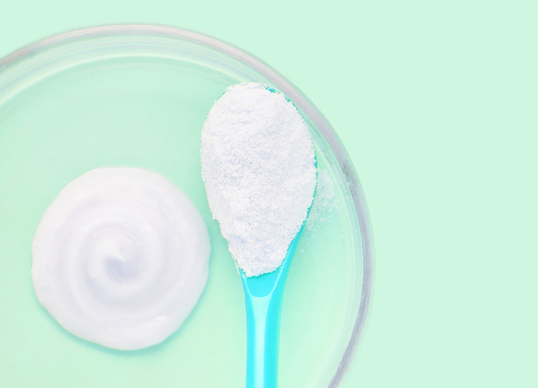 collagen powder in a scoop on a lightly green background